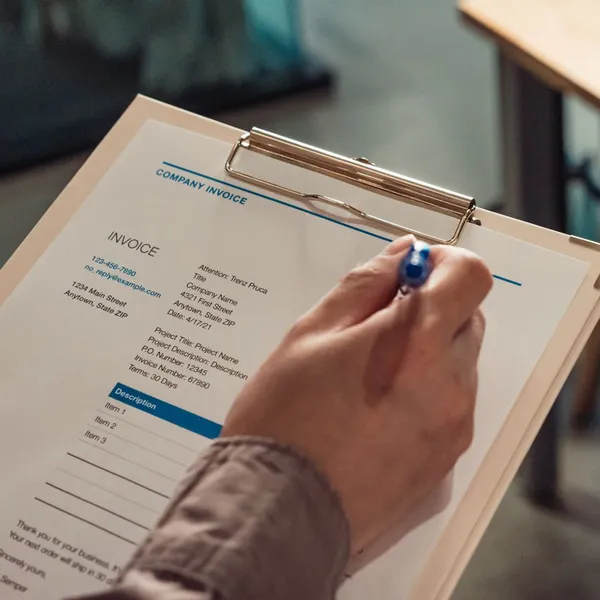 Reviewing a company invoice on a clipboard