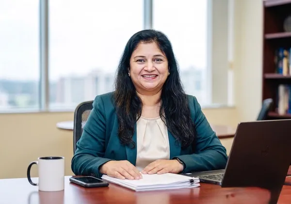 Padma Pothula reviewing financial documents at her desk